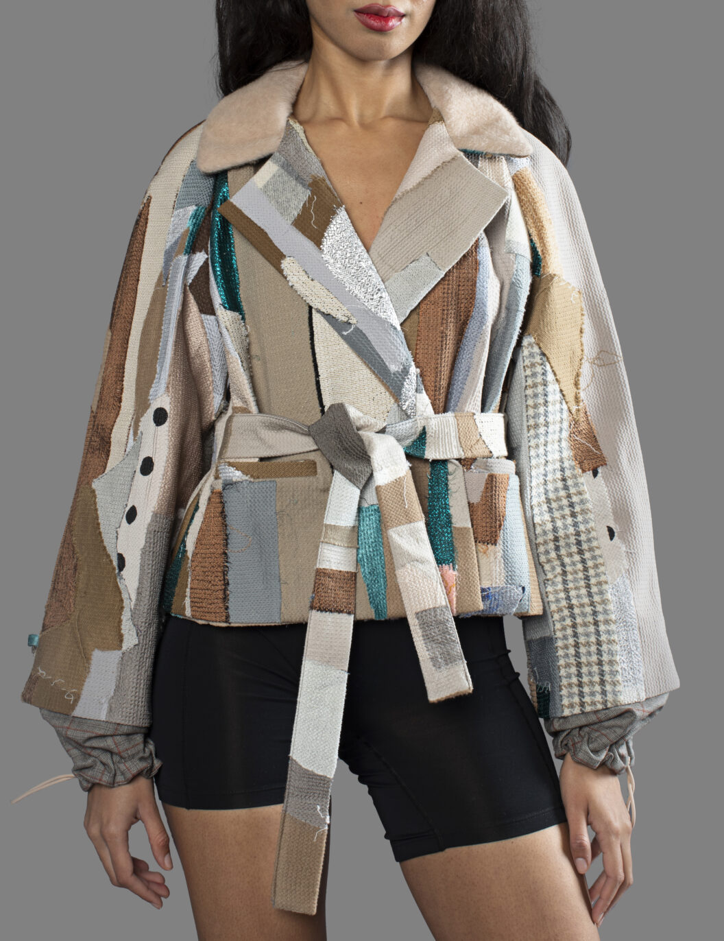 This is an image of a scrap suit jacket from the brand MiJA. It consists of mix of turquoise and beige fabrics.